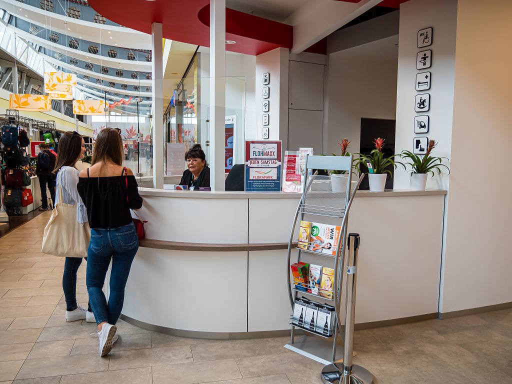 Kundeninformation im FLORAPARK mit Mitarbeiterin am Tresen